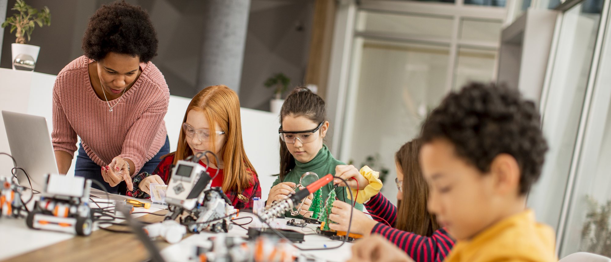A classroom of students building electronics and robotics projects together