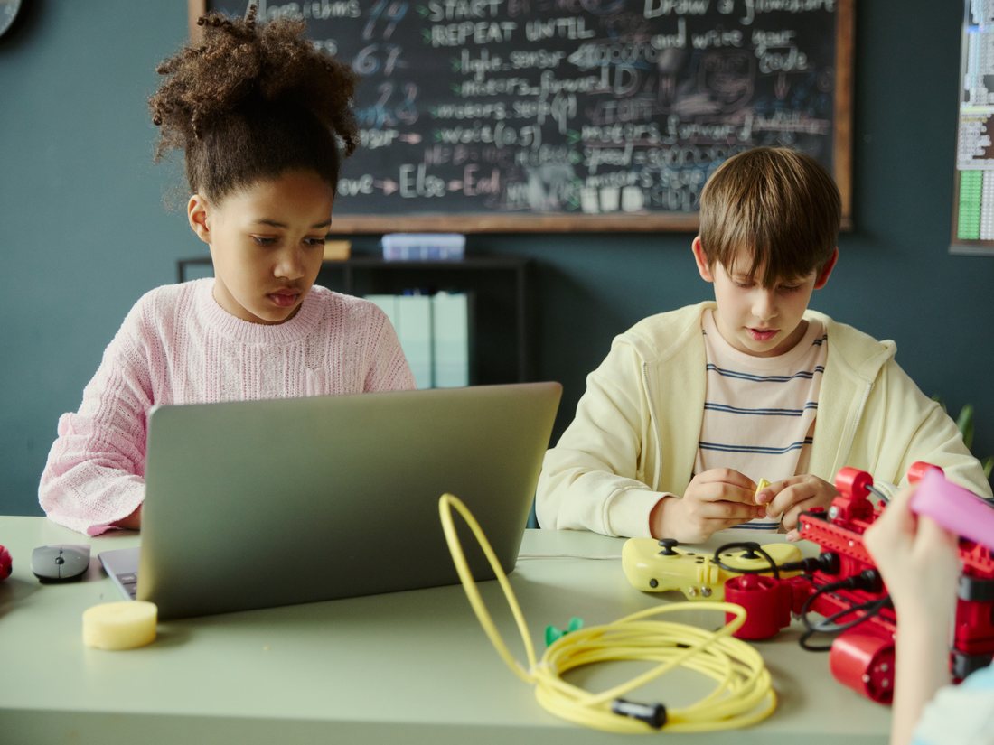 Two students at a laptop working through a project together