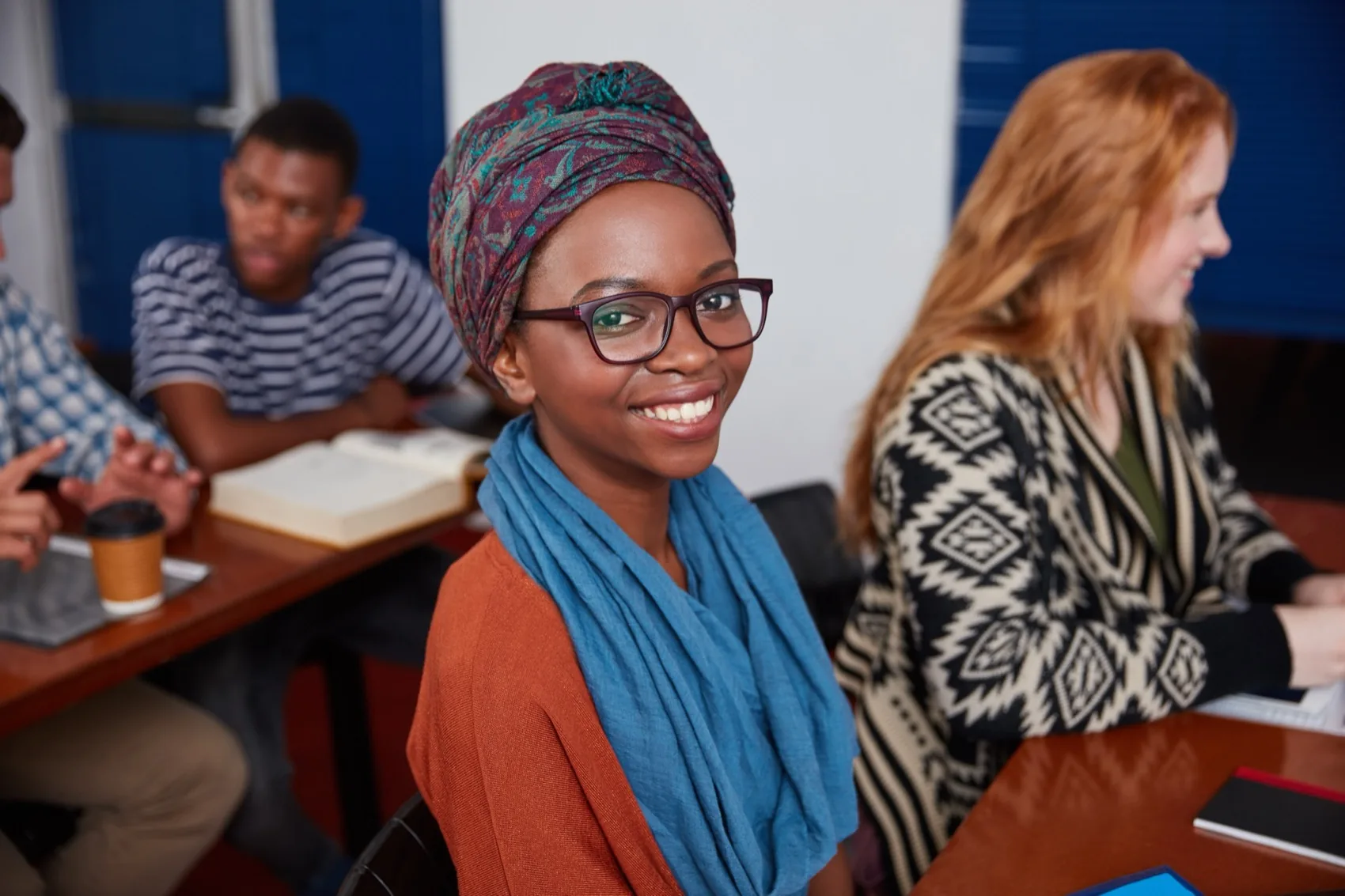 A young woman smiling in a classroom alongside other students