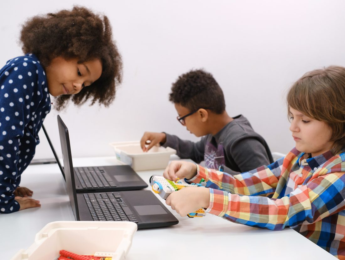 Children working side by side at laptops on their own game projects
